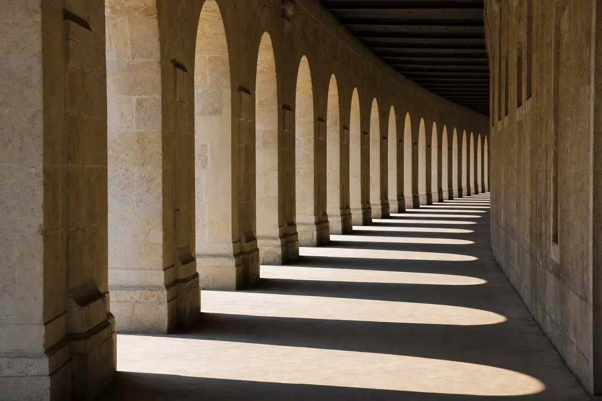 A long curving colonnade of identical arches receding into the distance, creating a rhythmic visual beat